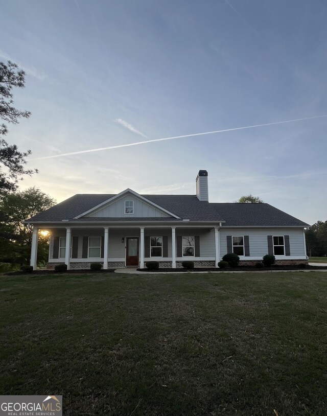 4529 Jersey Covington Rd, Covington, GA 30014 - view of front of home with a chimney, covered porch, a front lawn, and a shingled roof