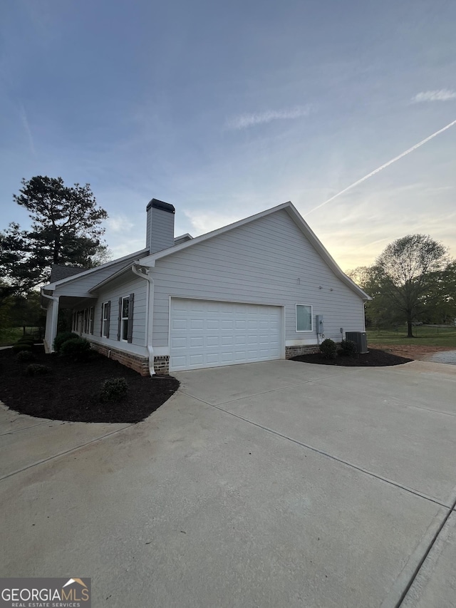 4529 Jersey Covington Rd, Covington, GA 30014 - view of side of home with a garage, driveway, a chimney, and cooling unit