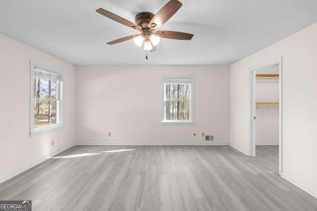 unfurnished bedroom with multiple windows, visible vents, and light wood-type flooring