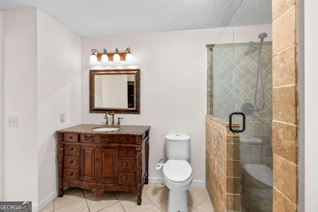 bathroom with baseboards, toilet, tile patterned floors, vanity, and a stall shower