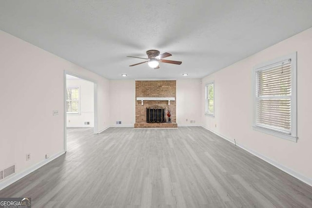 unfurnished living room with baseboards, a fireplace, wood finished floors, and ceiling fan