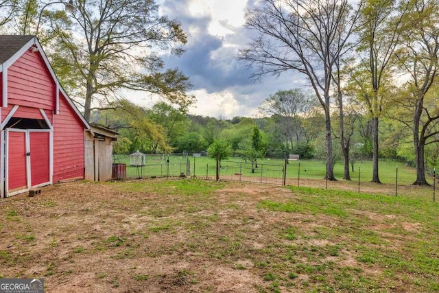 view of yard featuring an outbuilding and fence