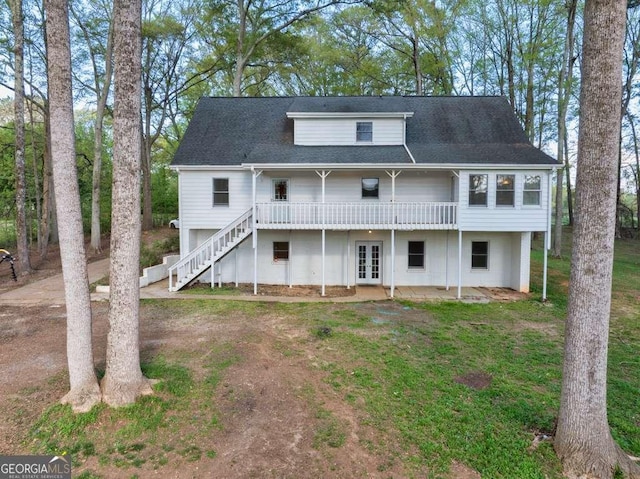 rear view of property featuring a wooden deck, stairway, french doors, and a yard