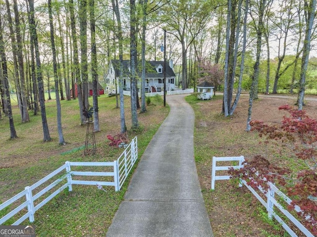 view of front of property featuring a front lawn, fence, and aphalt driveway