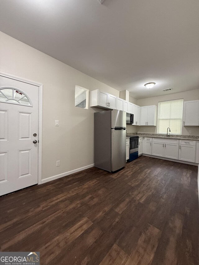 2728 Pecan St, Columbus, GA 31906 - kitchen featuring white cabinets, visible vents, dark wood-type flooring, baseboards, and black appliances