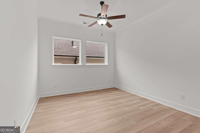 empty room with light wood-type flooring, baseboards, ceiling fan, and visible vents