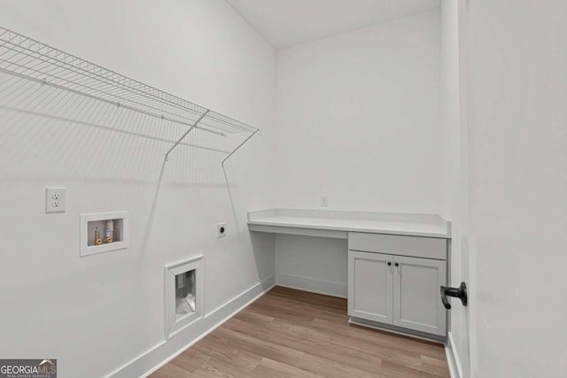 clothes washing area with baseboards, light wood-type flooring, washer hookup, and electric dryer hookup