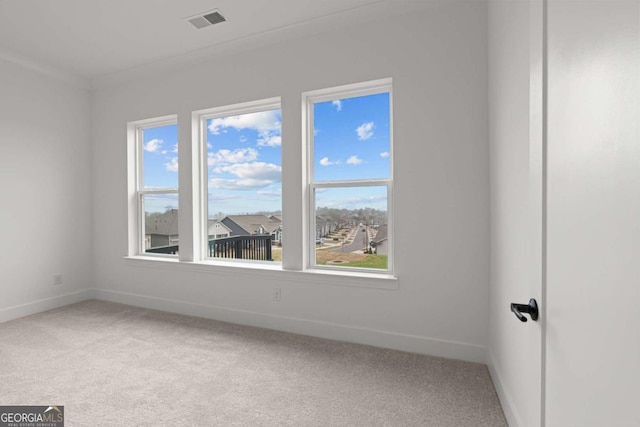 carpeted spare room featuring baseboards and visible vents