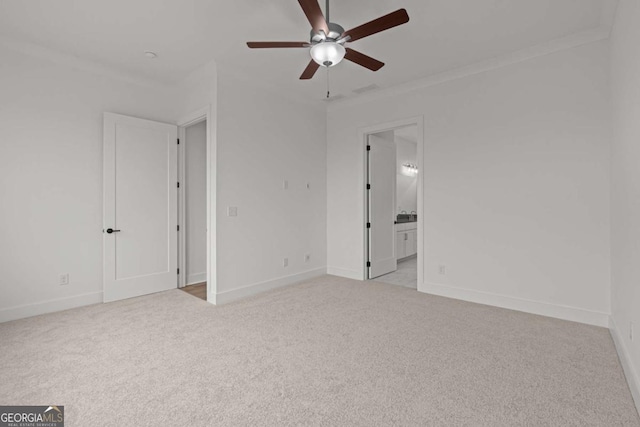 unfurnished bedroom with crown molding, a ceiling fan, ensuite bath, baseboards, and light colored carpet