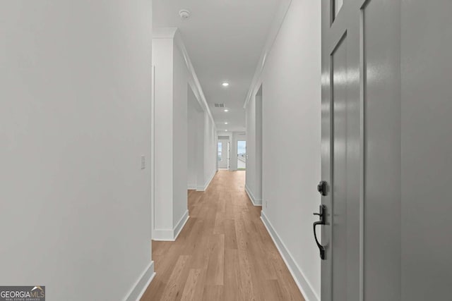hallway with crown molding, baseboards, visible vents, light wood-style floors, and recessed lighting