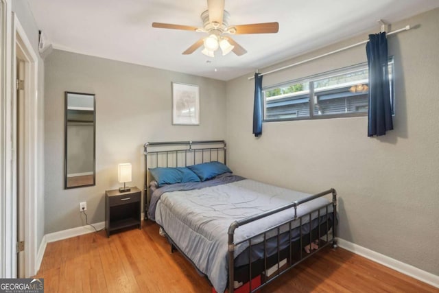 bedroom with baseboards, ceiling fan, and wood finished floors