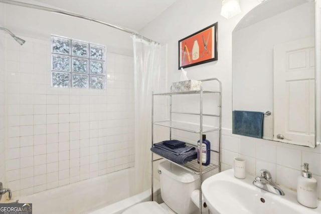 bathroom with shower / tub combo with curtain, toilet, decorative backsplash, tile walls, and a sink