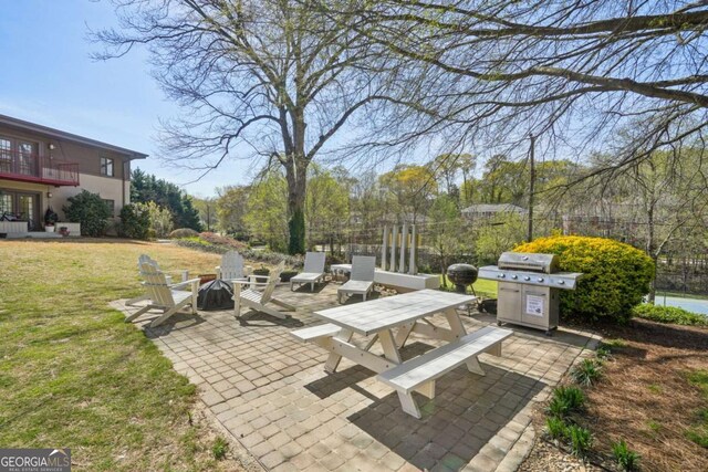 view of patio / terrace featuring grilling area, fence, and a balcony