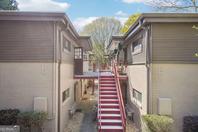 view of side of home featuring stairs and a wooden deck