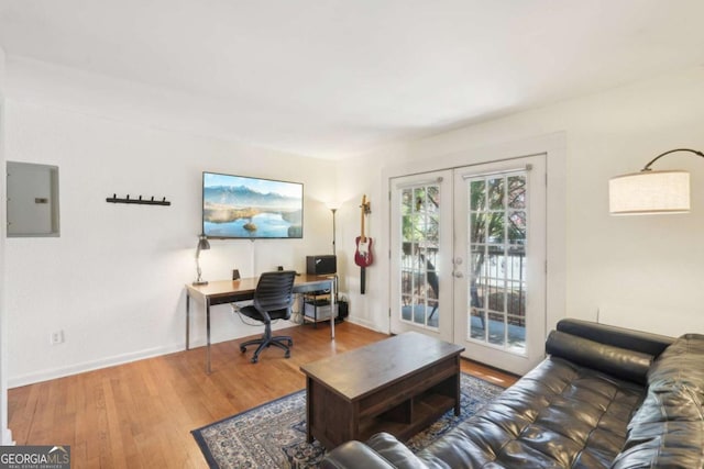 office with french doors, wood finished floors, baseboards, and electric panel