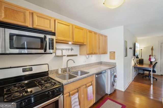 kitchen with washer / clothes dryer, baseboards, a sink, dark wood-style flooring, and stainless steel appliances