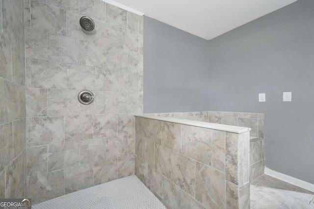 full bath featuring baseboards and a tile shower
