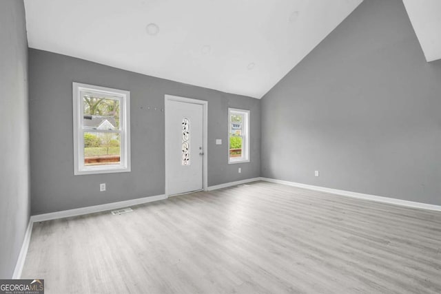 foyer featuring baseboards, visible vents, wood finished floors, and a healthy amount of sunlight