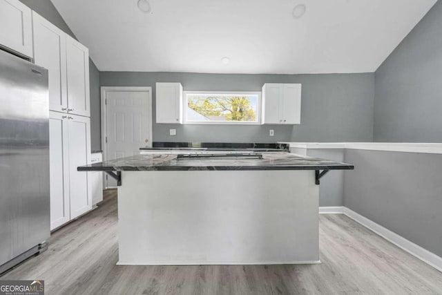 kitchen with a kitchen island, white cabinets, stainless steel fridge, and light wood finished floors