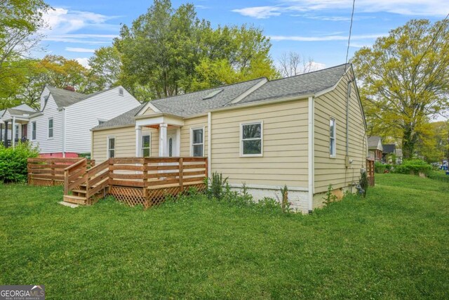 back of house featuring a deck and a yard