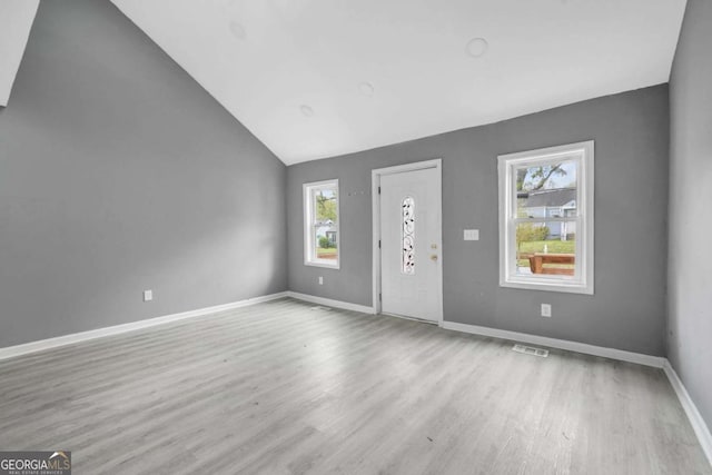 foyer featuring visible vents, baseboards, vaulted ceiling, and wood finished floors