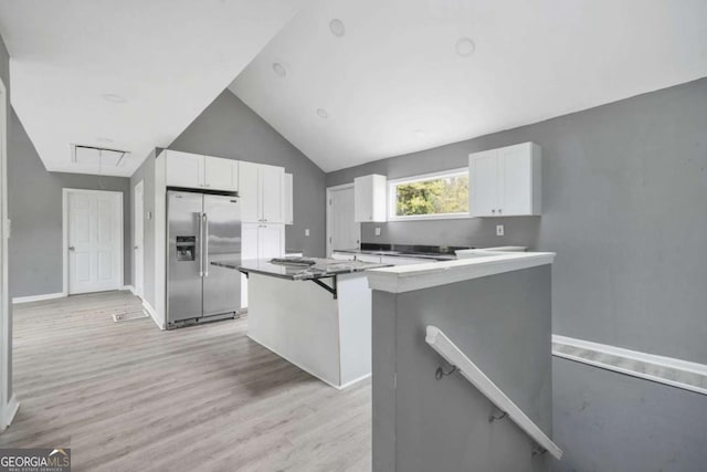 kitchen featuring white cabinets, stainless steel fridge, light wood-type flooring, and a center island