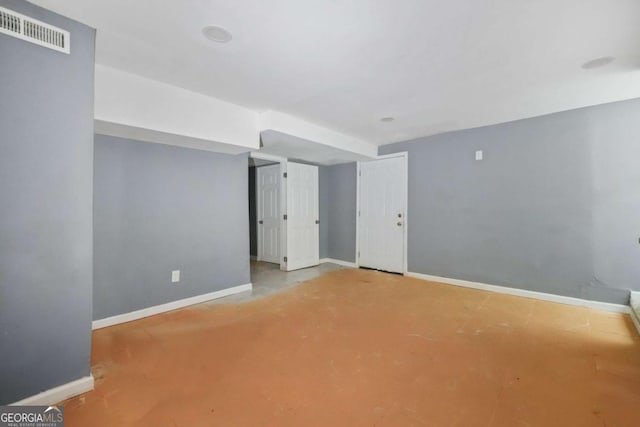 unfurnished room featuring concrete floors, baseboards, and visible vents