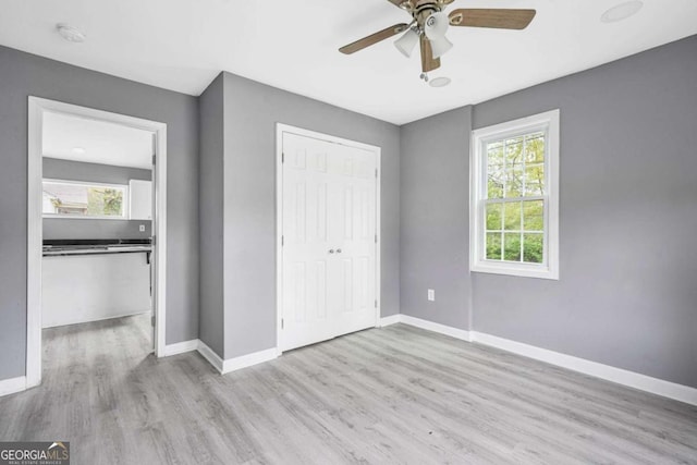 unfurnished bedroom featuring baseboards, a closet, and wood finished floors