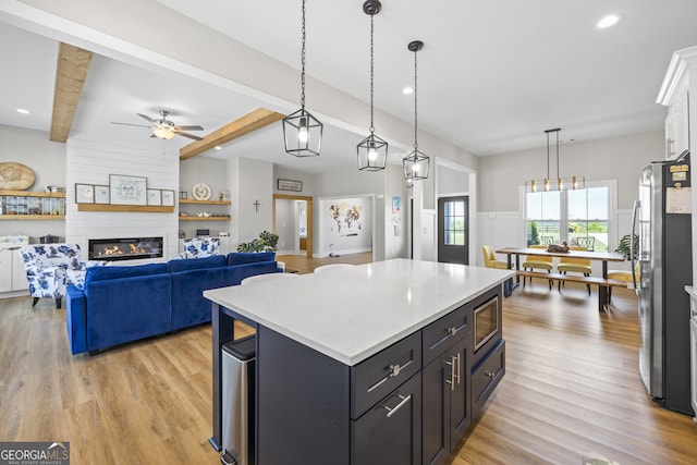 209 Unawatti Rd, Canon, GA 30520 - kitchen with a large fireplace, light wood-style floors, beamed ceiling, and appliances with stainless steel finishes
