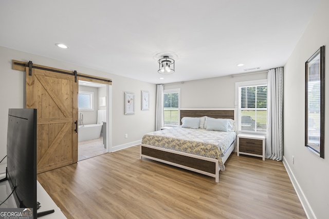 209 Unawatti Rd, Canon, GA 30520 - bedroom featuring a barn door, multiple windows, and light wood-type flooring