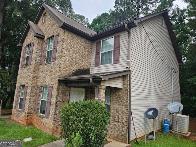 view of front of property featuring brick siding and central AC unit