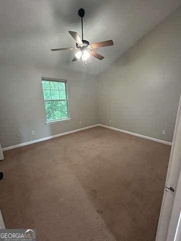unfurnished room with baseboards, carpet floors, lofted ceiling, and a ceiling fan
