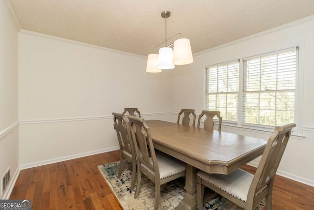 dining room featuring baseboards, wood finished floors, and ornamental molding