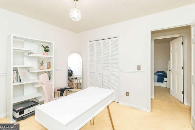 home office featuring light carpet and baseboards