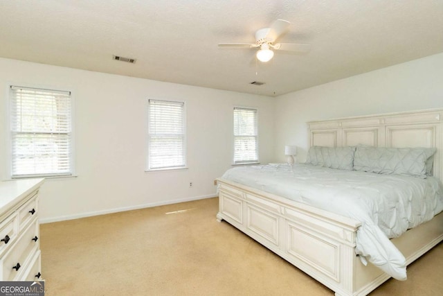 bedroom with light carpet, baseboards, visible vents, and a ceiling fan