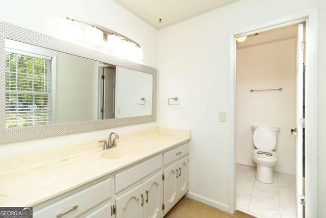 bathroom with baseboards, marble finish floor, toilet, and vanity