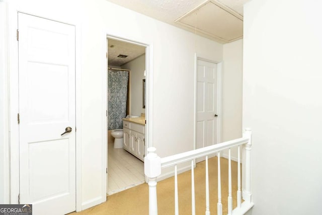 hall with attic access and an upstairs landing