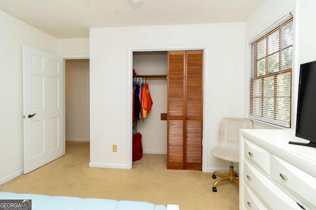 bedroom with multiple windows, a closet, baseboards, and carpet flooring