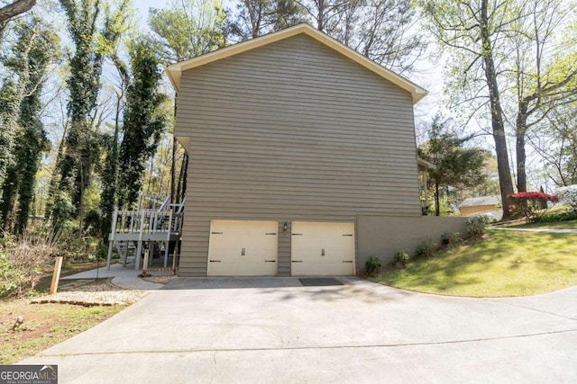 view of property exterior with driveway, an attached garage, and a yard