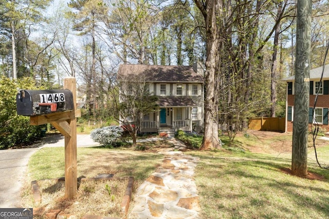 view of front facade with covered porch, brick siding, and a front lawn