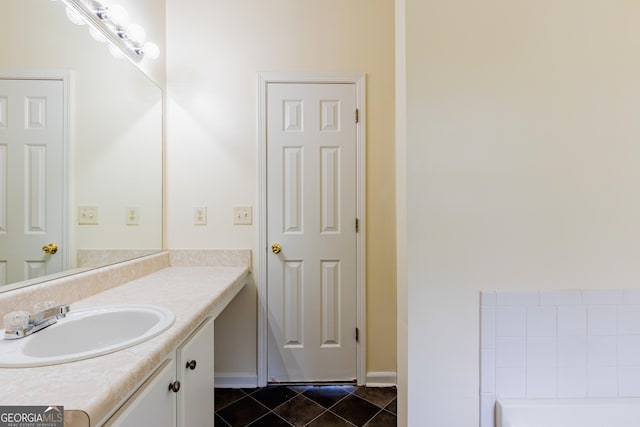 full bath with baseboards, a bathing tub, tile patterned floors, and vanity