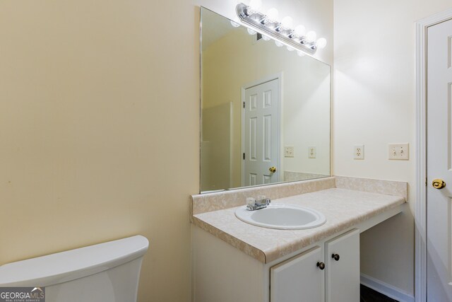 half bathroom with toilet and vanity