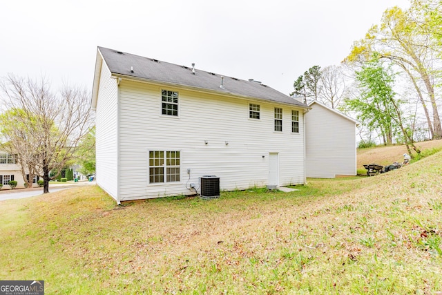 back of house with central AC and a yard
