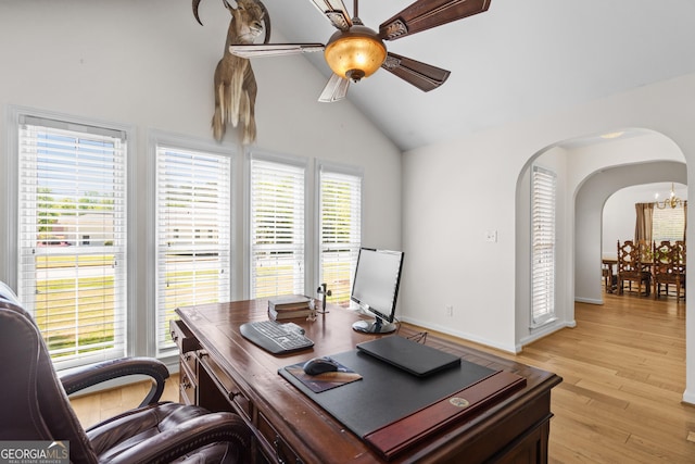 home office featuring arched walkways, light wood-type flooring, a ceiling fan, and a healthy amount of sunlight
