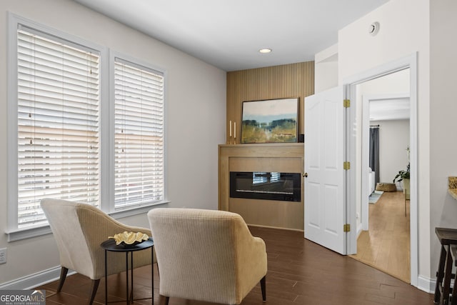 living area with a large fireplace, baseboards, recessed lighting, and dark wood-style floors