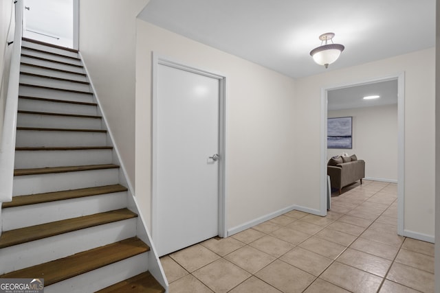 stairs featuring baseboards and tile patterned flooring