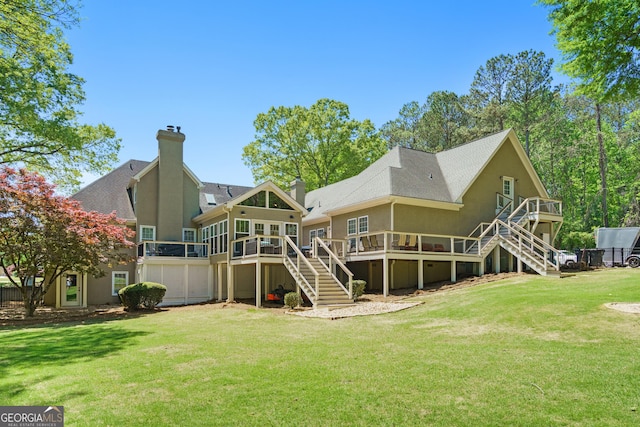 back of property with a yard, a chimney, a deck, and stairs