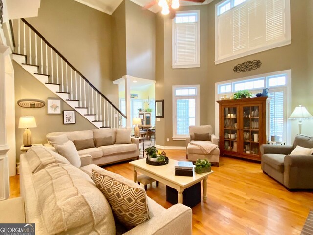 2210 Holly Springs Rd, Rockmart, GA 30153 - living area featuring light wood-style flooring, ceiling fan, stairs, and a high ceiling