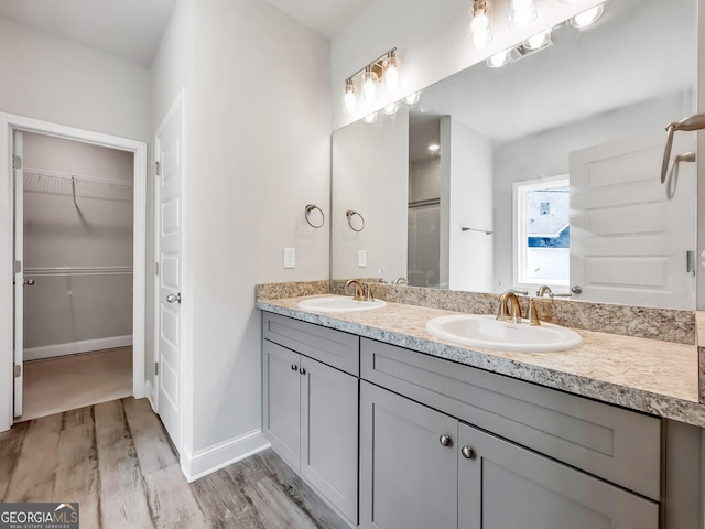 131 Hunts Mill Cir, Griffin, GA 30224 - bathroom featuring double vanity, wood finished floors, and a walk in closet