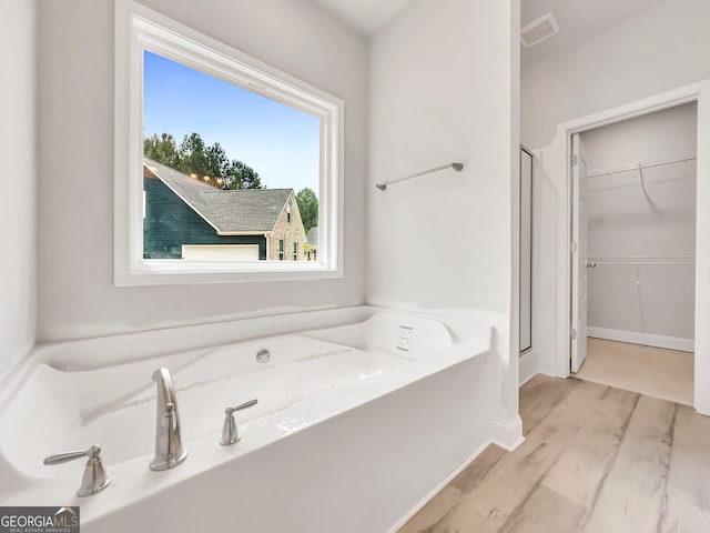 131 Hunts Mill Cir, Griffin, GA 30224 - full bathroom featuring a shower stall, a garden tub, a spacious closet, and wood finished floors